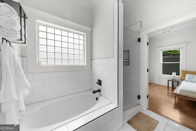 full bath with ornamental molding, a garden tub, and tiled shower