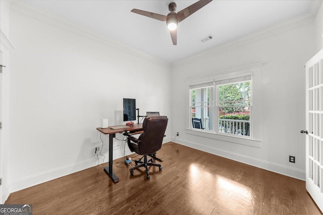 office space featuring a ceiling fan, baseboards, visible vents, crown molding, and wood finished floors