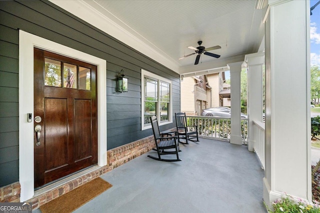 view of exterior entry featuring a porch and ceiling fan