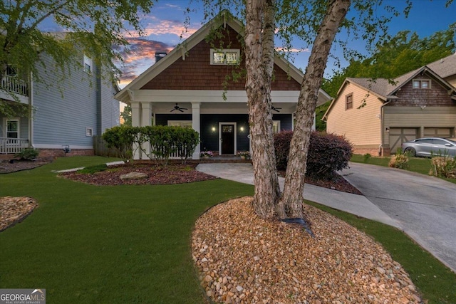 craftsman inspired home with concrete driveway, a front yard, a porch, and ceiling fan