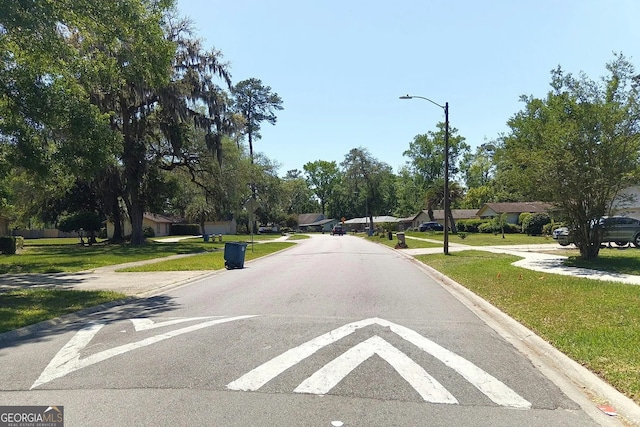 view of street with street lighting, sidewalks, and curbs