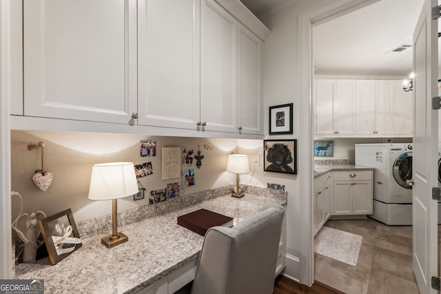 laundry area with cabinet space, washer / dryer, and visible vents