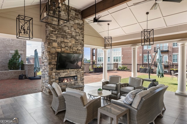 view of patio / terrace with an outdoor living space with a fireplace and a ceiling fan