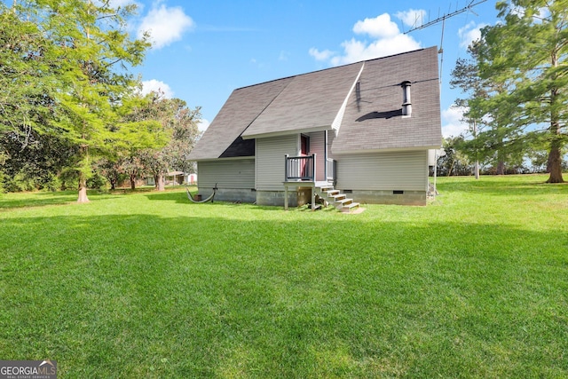 back of house with a yard and roof with shingles