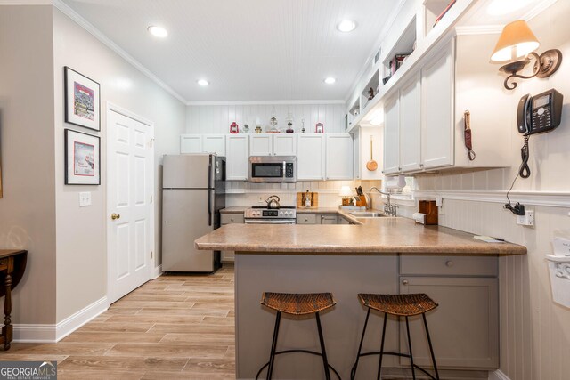 0 Vinson Mountain Rd, Rockmart, GA 30153 - kitchen with a breakfast bar area, appliances with stainless steel finishes, a sink, a peninsula, and light wood-style floors