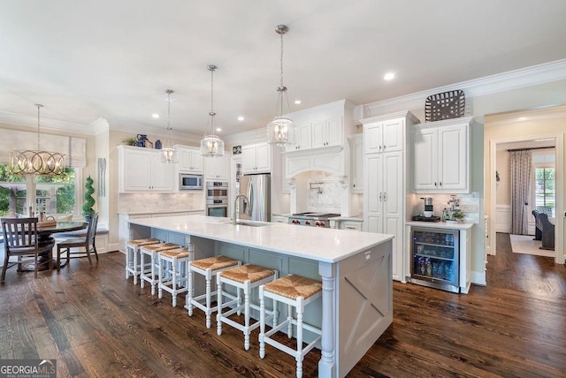 5475 Copper Creek Pass, Cumming, GA 30040 - kitchen featuring appliances with stainless steel finishes, beverage cooler, a chandelier, light countertops, and decorative backsplash