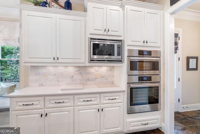 5475 Copper Creek Pass, Cumming, GA 30040 - kitchen with stainless steel appliances, ornamental molding, white cabinetry, backsplash, and light countertops