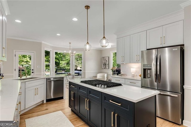 kitchen with light countertops, appliances with stainless steel finishes, white cabinets, and a peninsula