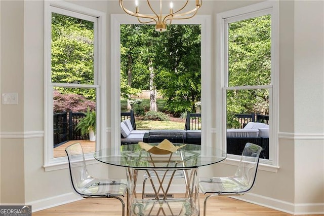 dining room with baseboards, wood finished floors, and a chandelier