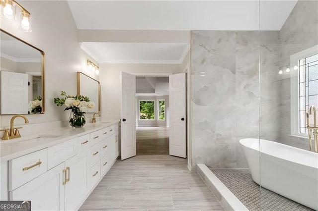 full bathroom featuring double vanity, ornamental molding, a sink, and a soaking tub
