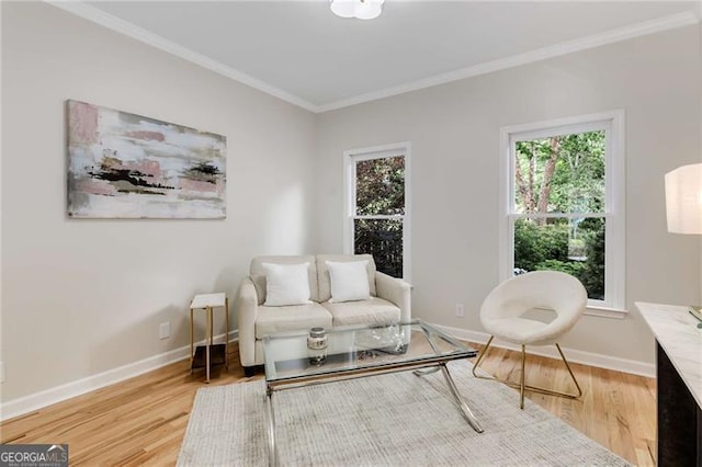 sitting room featuring crown molding, baseboards, and light wood finished floors