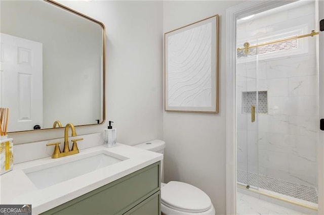 bathroom with toilet, a marble finish shower, and vanity