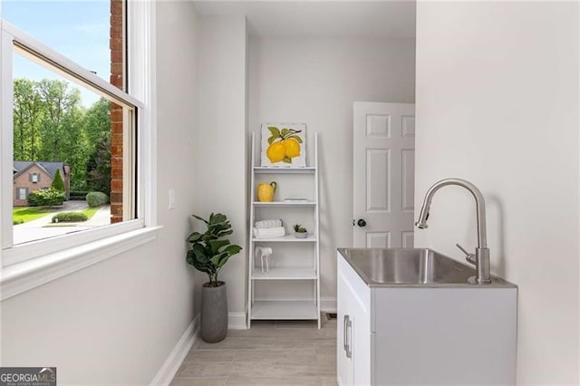 washroom with baseboards and a sink