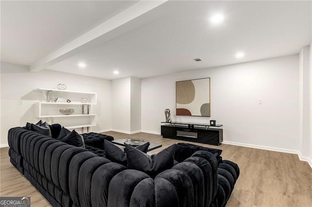 living room featuring recessed lighting, baseboards, light wood finished floors, and beam ceiling