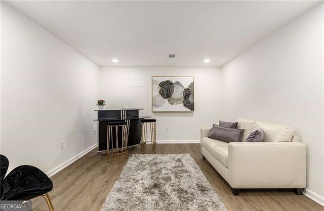 living area with recessed lighting, baseboards, and wood finished floors