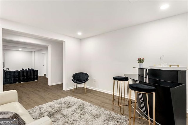 living area featuring baseboards, recessed lighting, and wood finished floors