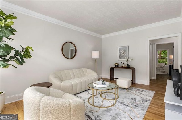 living room featuring baseboards, ornamental molding, and light wood finished floors