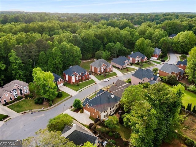 bird's eye view featuring a wooded view and a residential view