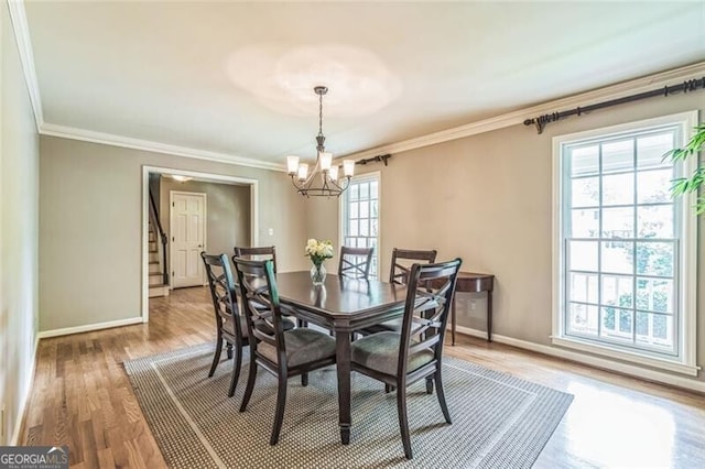 dining space with baseboards, ornamental molding, and a chandelier