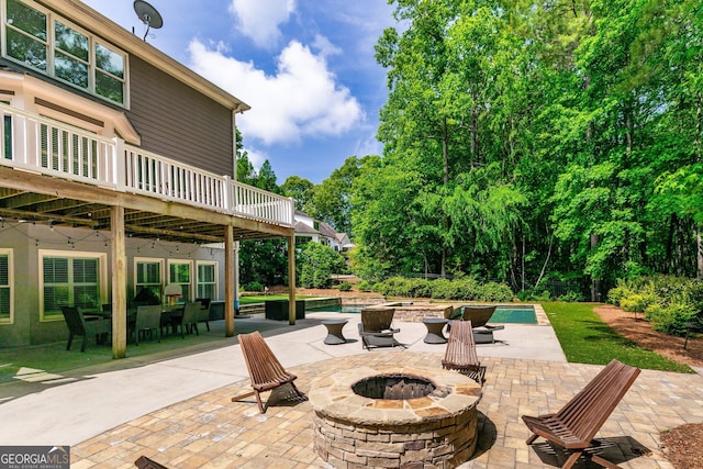 view of patio / terrace featuring a fire pit, an outdoor pool, and a wooden deck
