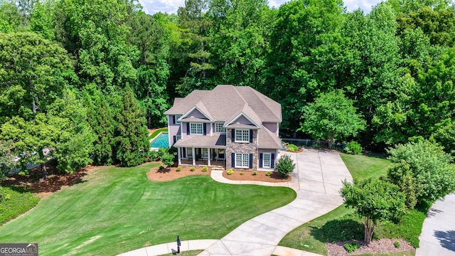 view of front of property with a porch, stone siding, and a front yard