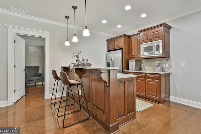 255 Ashmere Ct, Tyrone, GA 30290 - kitchen featuring appliances with stainless steel finishes, baseboards, a breakfast bar, dark wood-type flooring, and a peninsula