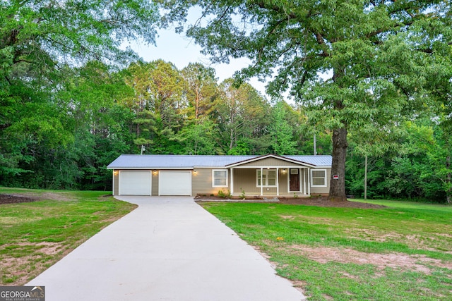 ranch-style house with concrete driveway, metal roof, and a front yard