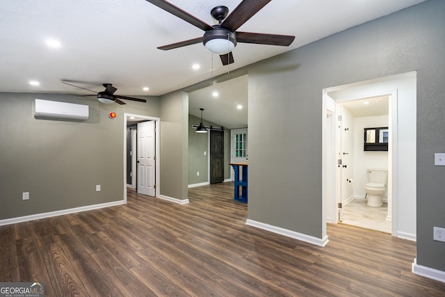unfurnished living room with an AC wall unit, a ceiling fan, wood finished floors, and a barn door
