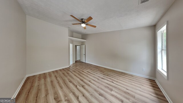 1229 Huntington Place Cir, Lithonia, GA 30058 - empty room with a textured ceiling, baseboards, a ceiling fan, and wood finished floors