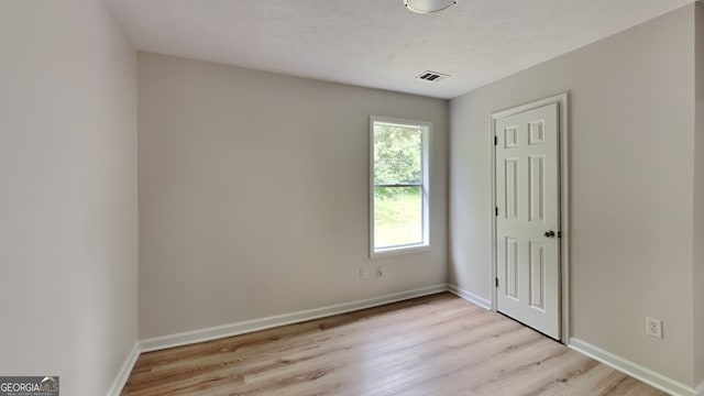 1229 Huntington Place Cir, Lithonia, GA 30058 - unfurnished bedroom with baseboards, light wood finished floors, a textured ceiling, and visible vents