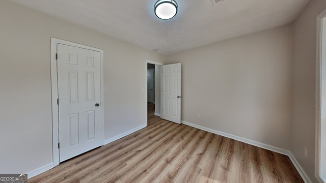 1229 Huntington Place Cir, Lithonia, GA 30058 - unfurnished bedroom with light wood-style floors and baseboards
