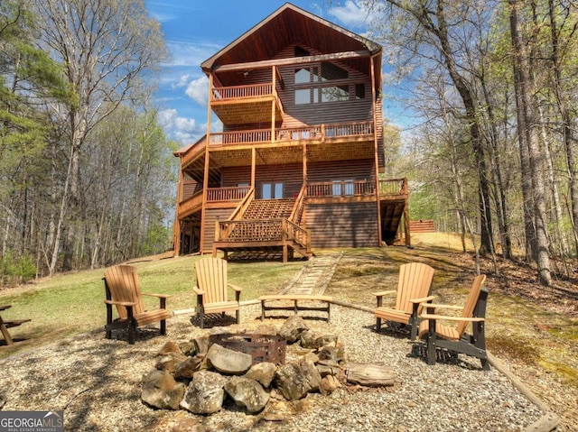 143 Katydid Rd, Morganton, GA 30560 - back of property featuring a balcony, a deck, faux log siding, stairs, and an outdoor fire pit
