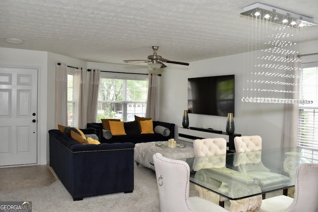 living area featuring plenty of natural light, a ceiling fan, and a textured ceiling
