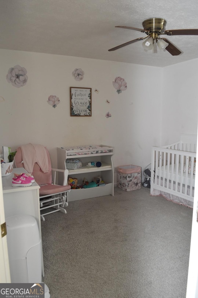 interior space with a crib and ceiling fan