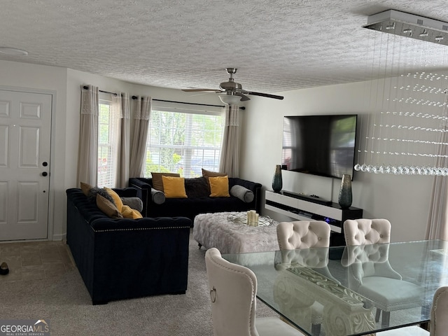 carpeted living room featuring ceiling fan and a textured ceiling