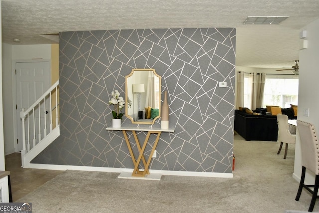 room details featuring a textured ceiling, ceiling fan, visible vents, and an accent wall
