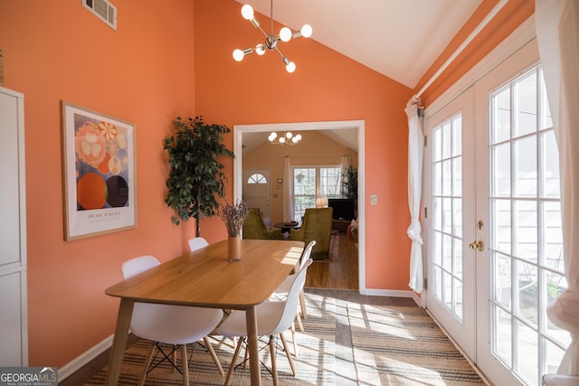 dining space featuring baseboards, visible vents, french doors, and a notable chandelier