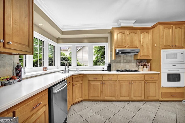 kitchen with white appliances, a sink, crown molding, light tile patterned flooring, and decorative backsplash