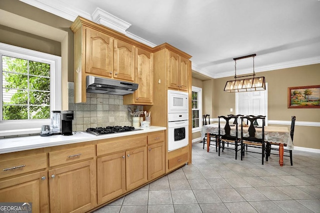 kitchen with white appliances, under cabinet range hood, light tile patterned floors, tasteful backsplash, and light countertops