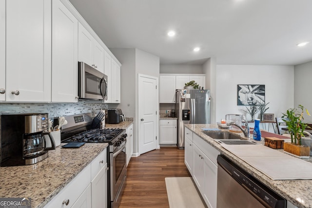 4777 Waxwing St, Hoschton, GA 30548 - kitchen featuring dark wood-type flooring, recessed lighting, white cabinets, a sink, and appliances with stainless steel finishes