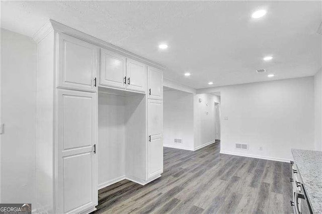 kitchen featuring recessed lighting, dark wood-style floors, baseboards, white cabinets, and light stone counters