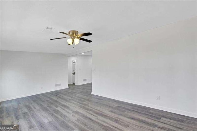 empty room featuring wood finished floors, ceiling fan, and baseboards