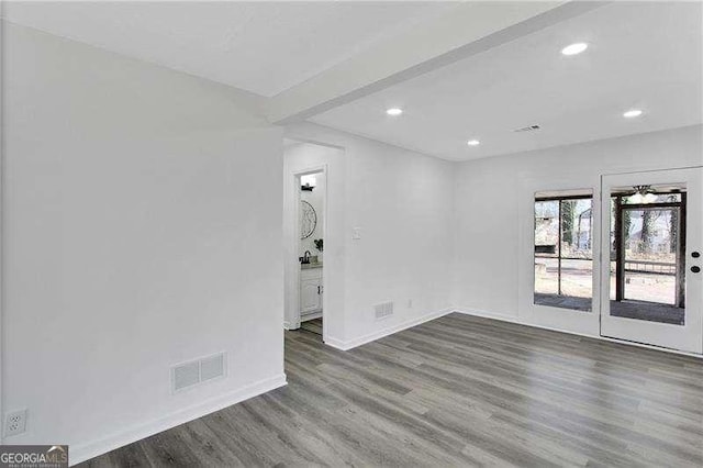 empty room featuring wood finished floors, recessed lighting, and baseboards