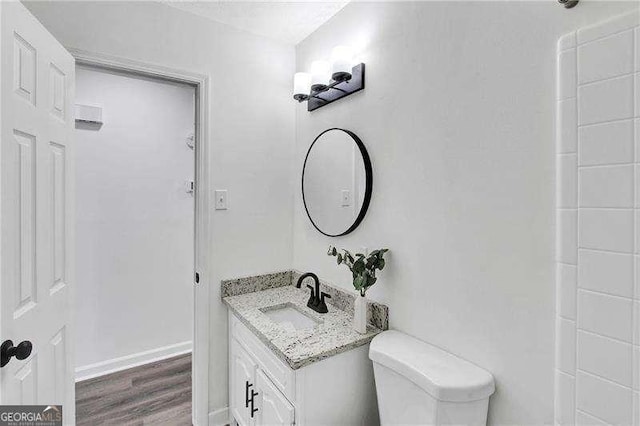 bathroom with vanity, wood finished floors, and toilet