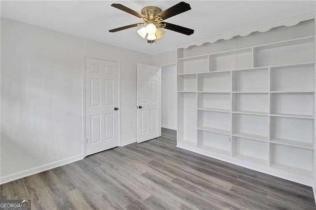unfurnished bedroom featuring wood finished floors, baseboards, and ceiling fan
