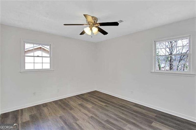 empty room featuring dark wood-type flooring, baseboards, and ceiling fan