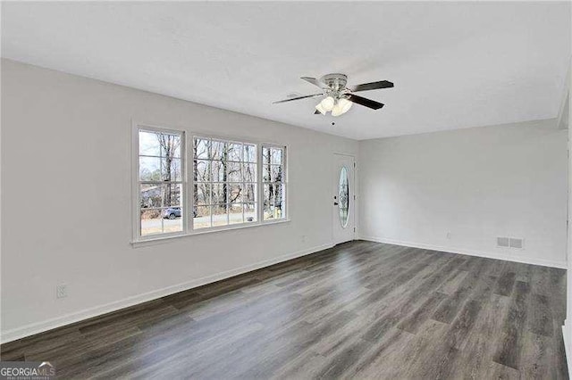 unfurnished living room with ceiling fan, dark wood-style floors, and baseboards