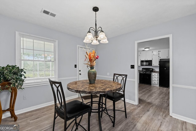 100 Fairview Dr, Stockbridge, GA 30281 - dining area featuring a chandelier, baseboards, visible vents, and light wood-type flooring