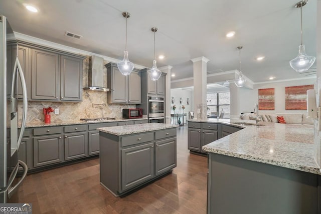 317 Basel Way, Hampton, GA 30228 - kitchen with gray cabinets, wall chimney range hood, appliances with stainless steel finishes, crown molding, and a spacious island
