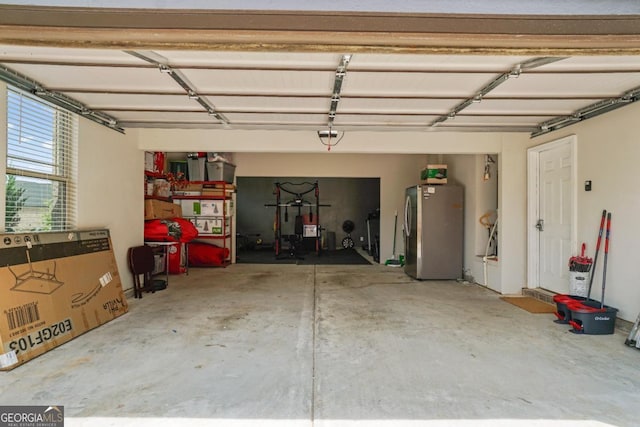 317 Basel Way, Hampton, GA 30228 - garage featuring freestanding refrigerator and a garage door opener